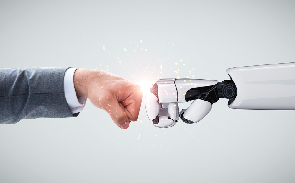 Human and AI robot bumping fists